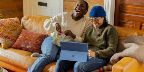 a person sitting on a couch with a laptop