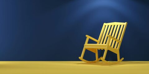 a wooden rocking chair sitting on top of a yellow floor