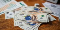 Brazilian currency notes on a wooden table surface.