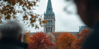 Canada's Parliament Hill with autumn leaves and cloudy sky.