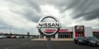 Nissan dealership with empty lots and overcast skies.