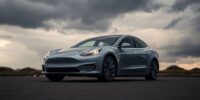 Tesla car under dark clouds, indicating market uncertainty.