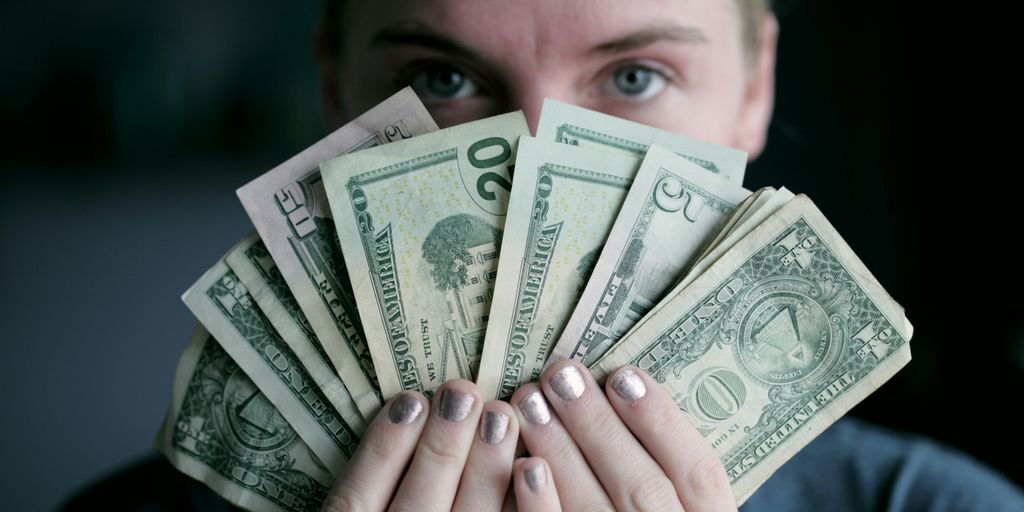 person holding fan of U.S. dollars banknote