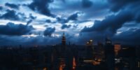 Dusk skyline with dramatic clouds and city lights.
