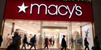 Macy's bustling storefront with holiday decorations and shoppers.