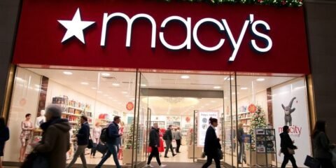 Macy's bustling storefront with holiday decorations and shoppers.